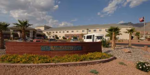 Front exterior view of Royal Estates of El Paso with palm trees and signage.
