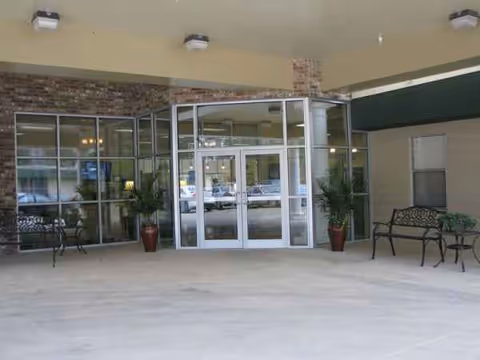 Oak Haven Community Care Center front entrance featuring glass doors, brick facade, and potted plants.