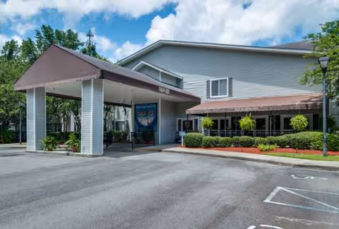 Exterior view of Oaks at Savannah entrance with porte-cochère and landscaped walkway.