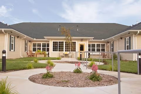 Single-story Prairie Senior Cottages exterior with a circular mulched garden and seating area.