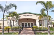 Front entrance of the Avante at Melbourne senior living building with a covered portico, palm trees, and a brick walkway.