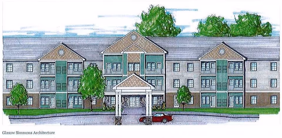 Architectural drawing of a three-story senior living facility building with a covered entrance, multiple windows, balconies, and surrounding trees and greenery.