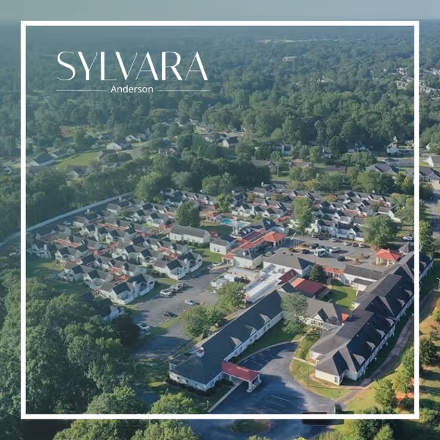 Aerial view of Sylvara Anderson senior living facility showing multiple residential buildings, parking areas, and surrounding greenery.