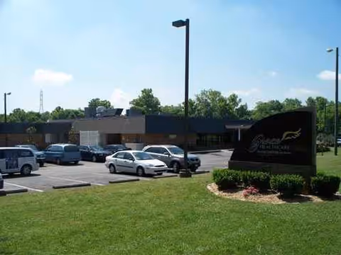 Exterior view of Whites Creek Wellness & Rehabilitation Center with parked cars and sign.