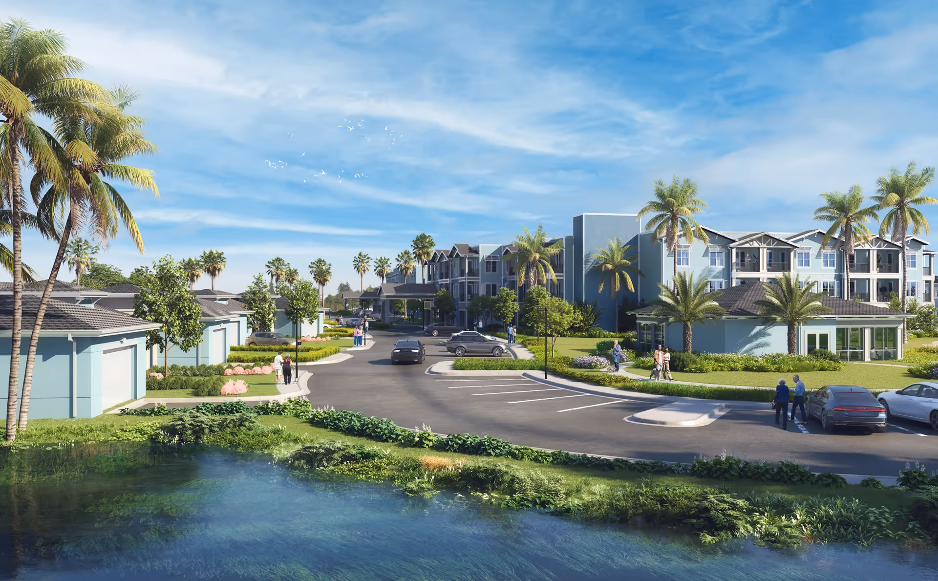 Exterior view of The Gallery at South Tampa senior living facility featuring a large building with balconies, palm trees, a parking lot with cars, walking paths, and a pond in the foreground under a blue sky with scattered clouds.