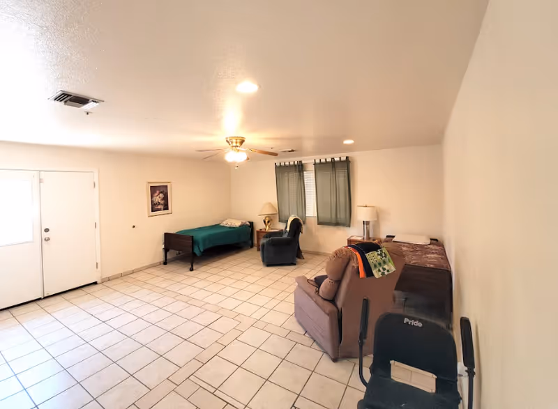 Spacious tiled living room with two single beds, recliners, a ceiling fan, and a curtained window.