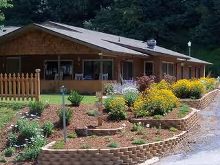 Single-story building with landscaped garden and brick planters in foreground.