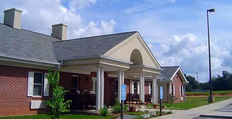 Brick exterior of Rocky River Baptist Residential with a covered entrance and benches.