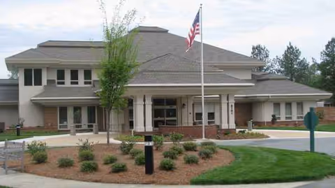 Front view of Twin Lakes Community Memory Care building with flagpole and landscaped entrance.