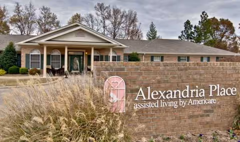Exterior of Alexandria Place assisted living facility with brick sign and front entrance.