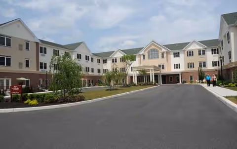 A multi-wing senior living facility with a curved driveway and welcoming front entrance.
