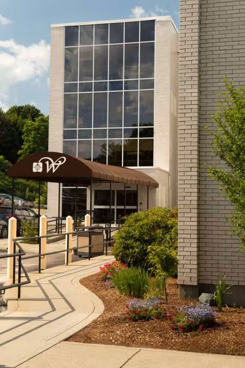 Exterior view of Bear Mountain Worcester entrance with glass facade and landscaping.