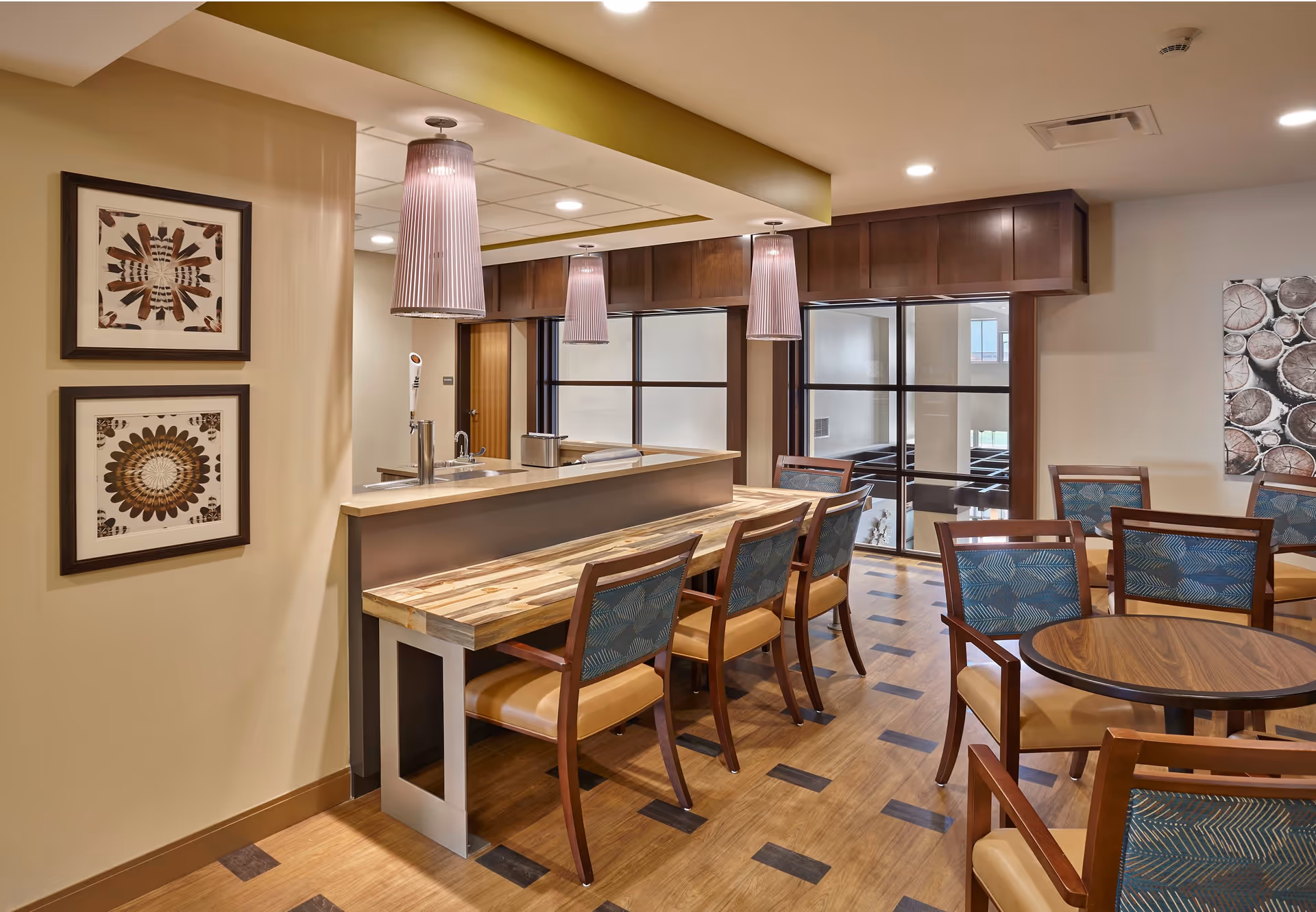 Interior dining area with a high-top counter, bar seating, pendant lights, and several round dining tables and chairs.