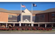 Front view of a brick senior living facility with flags and manicured landscaping.