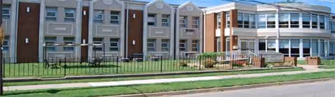 Exterior view of Shepherd's Village at Park Avenue building with brick facade and lawn.