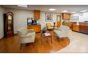 Lobby seating area with two beige armchairs, a small table, and a reception desk.