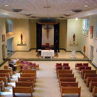 Chapel area inside a senior home with pews facing an altar and crucifix