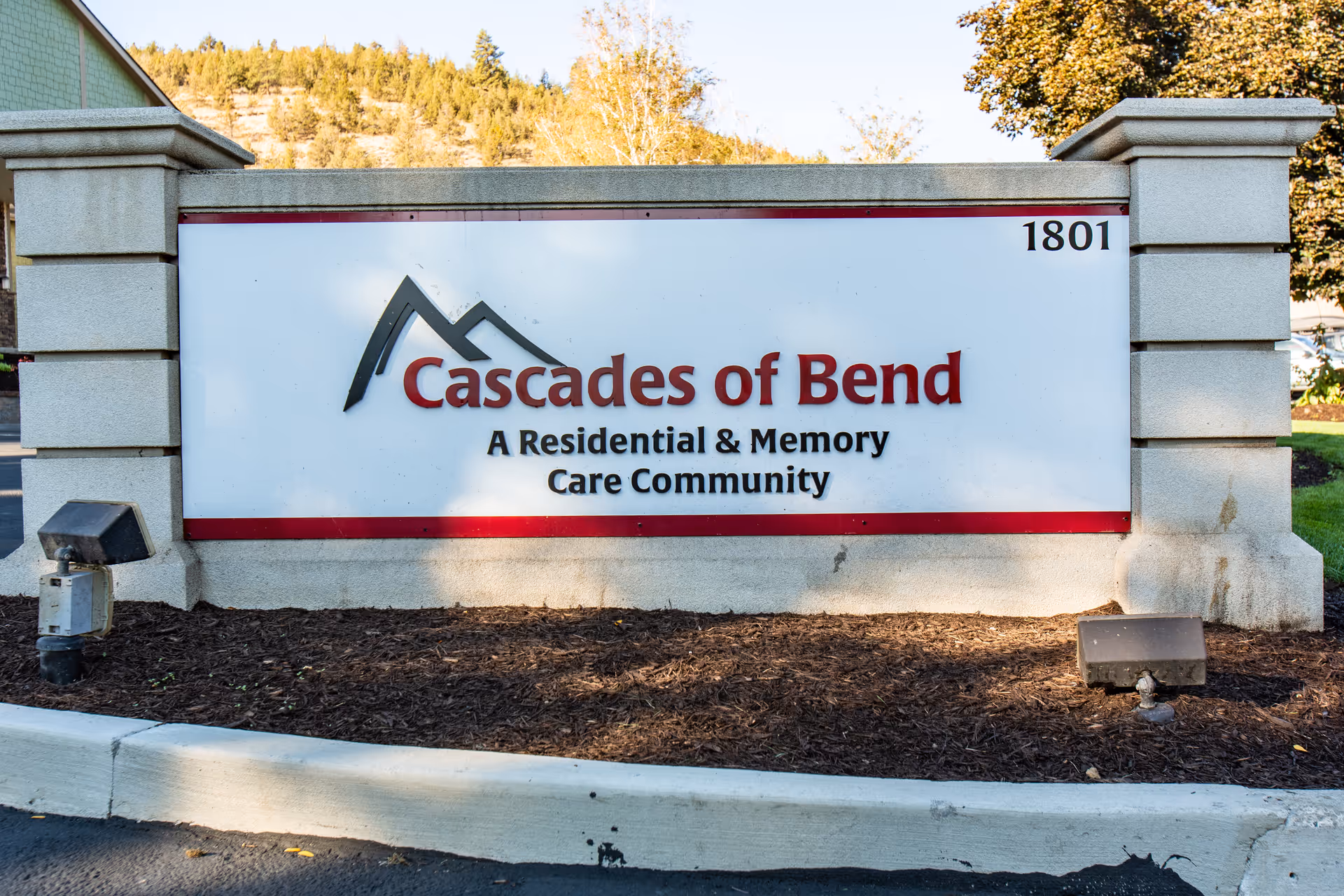 Entrance sign reading "Cascades of Bend – A Residential & Memory Care Community" with the address number 1801.