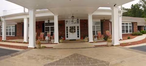 Front entrance of Fremont Rest Center with brick facade, white columns, and seating.