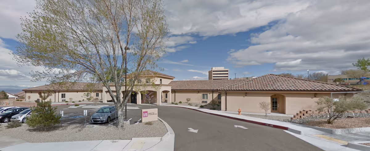 Exterior view of Brio Assisted Living facility with circular driveway and parked cars.