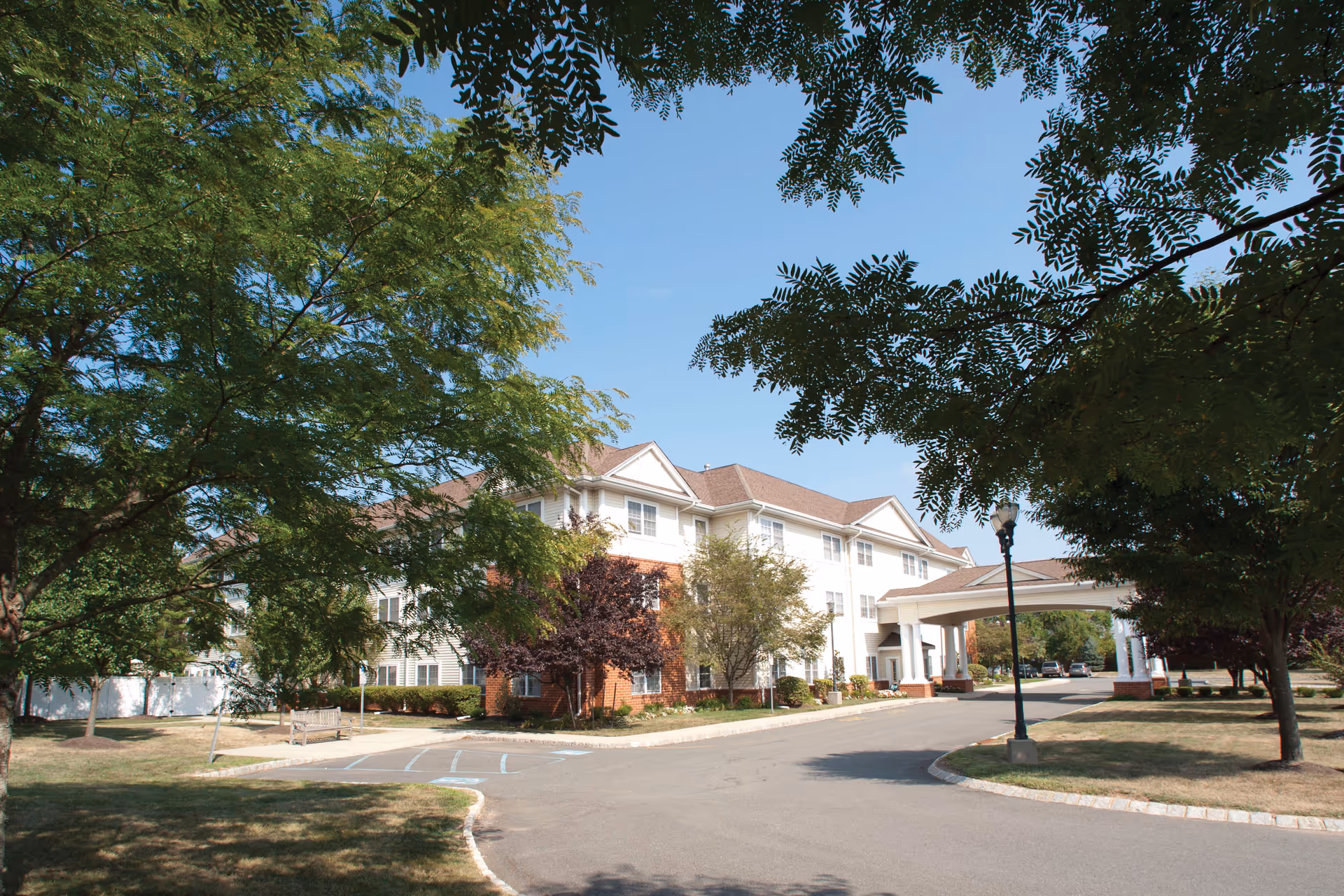 Exterior view of Brandywine Pennington by Monarch, showing a multi-story senior living facility entrance.