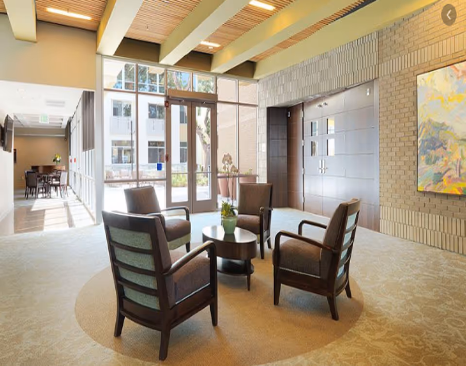The Avant lobby with circular seating, coffee table, and glass entry doors.