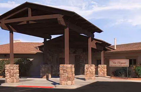 Stone pillars support a wooden porte-cochère at the facility's front entrance.