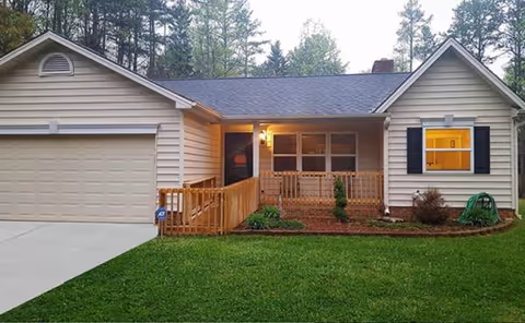 A single-story senior living home with front porch, attached garage, and well-kept lawn