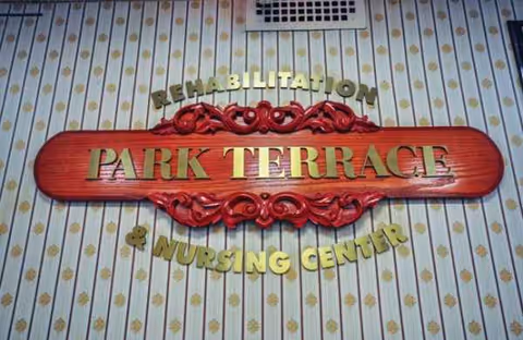 A decorative red sign reading Park Terrace Rehabilitation Nursing Center mounted on striped interior wallpaper.