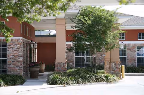 Exterior view of Belle Teche Nursing & Rehabilitation Center entrance with brick columns and landscaping.
