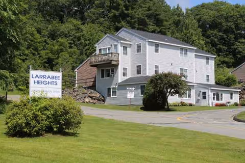 Two story light gray building with a sign reading Larrabee Heights and surrounding lawn.