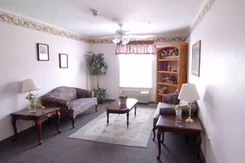 Cozy living room with two sofas, lamps, a coffee table, and a bookshelf.