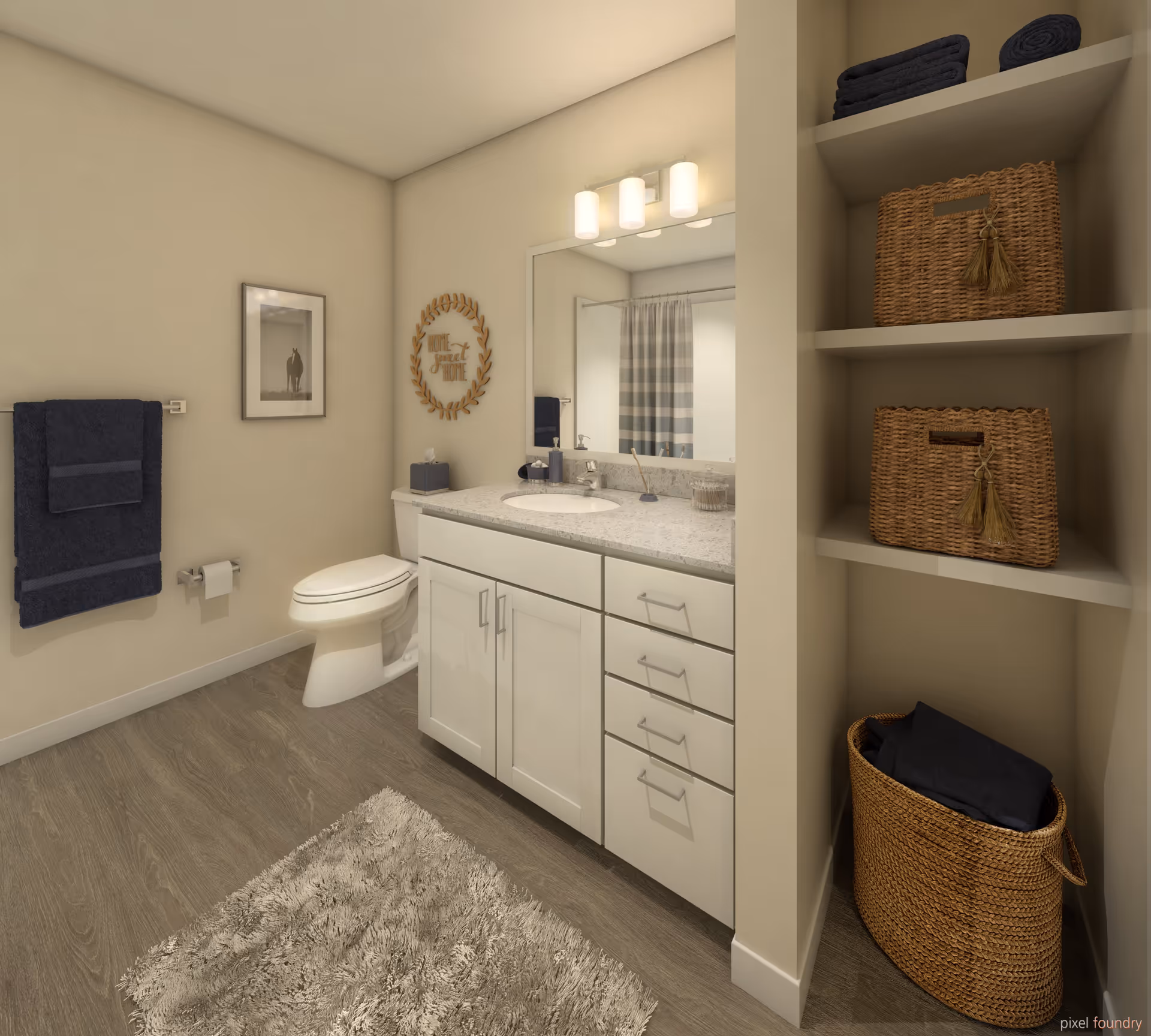 A clean and modern bathroom with a white toilet, a vanity with a granite countertop and an oval sink, a large mirror with three light fixtures above it, and built-in shelves holding woven baskets and folded towels. There is a framed picture and a towel rack with dark towels on the wall, and a soft textured rug on the wooden floor.