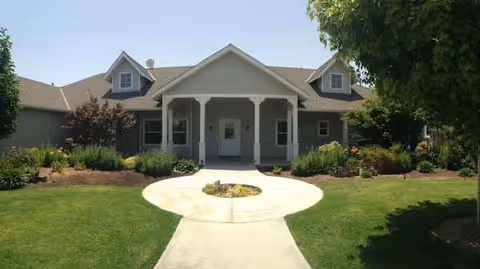 Front view of Evergreen Meadows senior living facility with landscaped grounds and circular walkway.