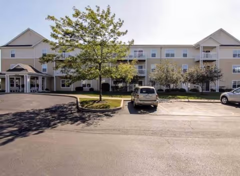 Exterior view of Highland Village I and II Senior Apartments with parking and trees.