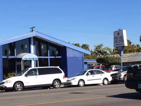 Blue building exterior of Royal Oaks Care Center with parked cars in front