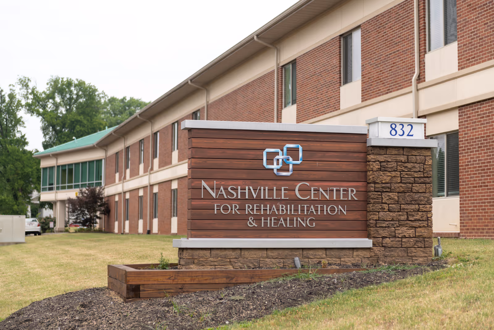 Wooden sign reading "Nashville Center for Rehabilitation & Healing" in front of a two-story brick facility with address number 832.