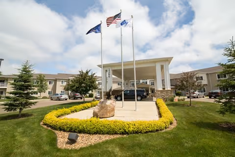 Front view of Edgewood Hawks Point with flagpoles, entry canopy, and landscaped entrance.