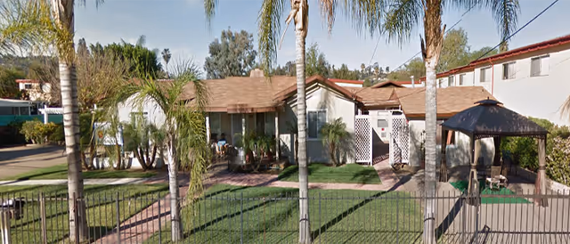 Parkway Garden Retirement Care Home front exterior with palm trees, lawn, and shaded porch.