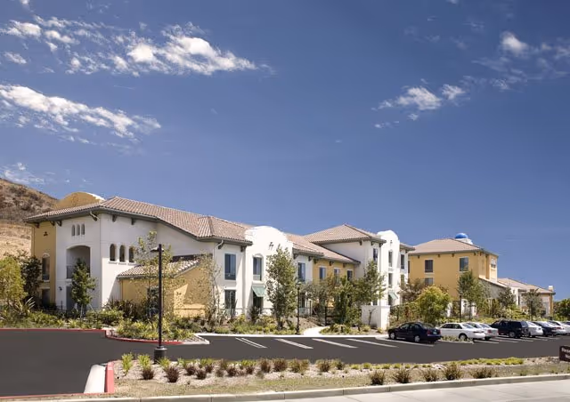 Exterior view of Belmont Village Senior Living Thousand Oaks campus with parking and landscaping.