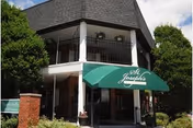 Exterior entrance of St. Joseph's Villa Center with green awning and greenery.