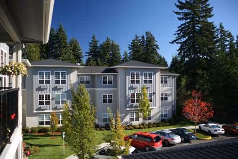 Exterior view of Cedar Ridge by Bonaventure with parked cars and trees.