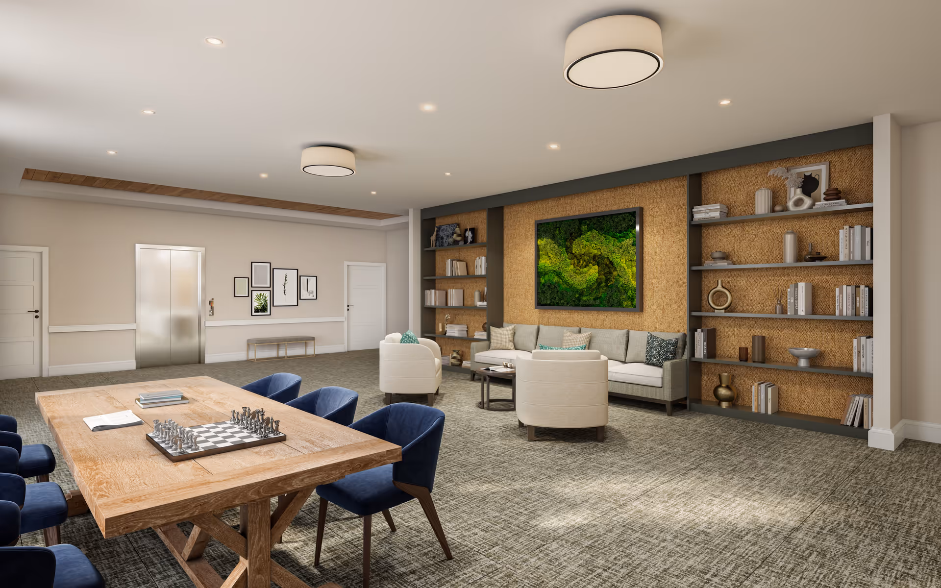 Spacious communal lounge with a long wooden table and blue chairs, a seating area with sofas and built-in bookshelves, and wall art.