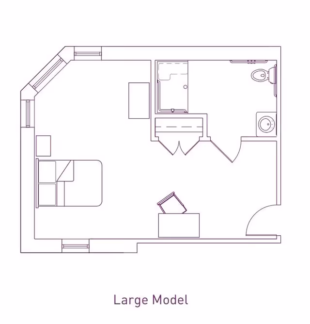 Architectural floor plan of a large model room at Franklin Place Memory Care, showing a bedroom area with a bed and nightstand, a bathroom with a shower, toilet, and sink, and a small desk with a chair.