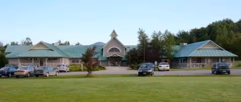 Front view of Our Lady of the Meadows & Ave Maria Home, with cars parked.