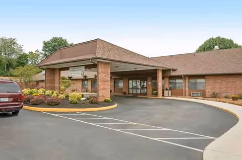 Front view of a brick Life Care Center entrance with parking area