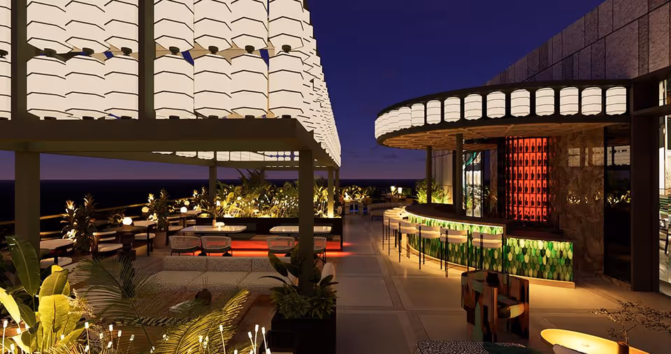 Outdoor patio area at night with modern seating arrangements, illuminated hanging lanterns, plants, and a curved bar with green and red lighting accents.