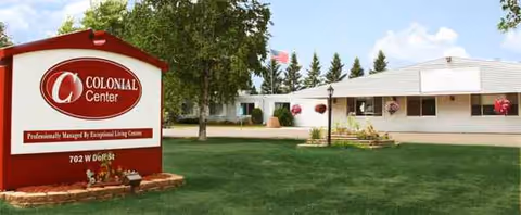 Exterior view of Colonial Center building with lawn and sign.