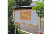 Outdoor sign reading 'The Care Center of Honolulu' surrounded by tropical plants.