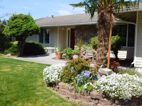 A single-story facility with a landscaped front yard, shrubs, and entrance walkway.